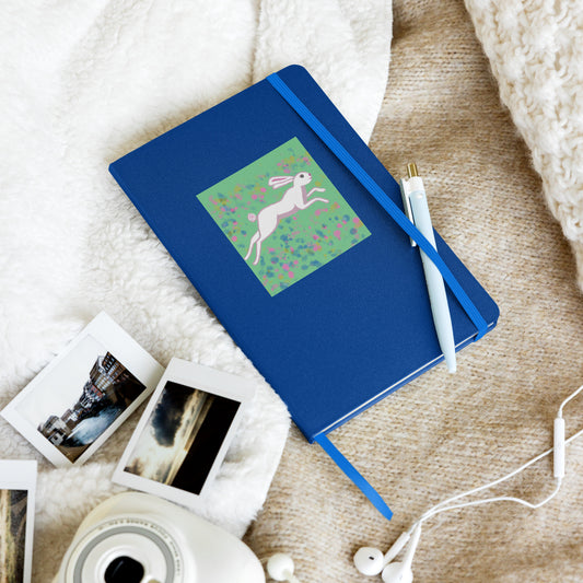 Hardcover journal or notebook in blue with an original painting of a wild hare or rabbit on a field of flowers. The hare is a trickster spirit guide that inspires the artist in you. Great journal for morning pages.