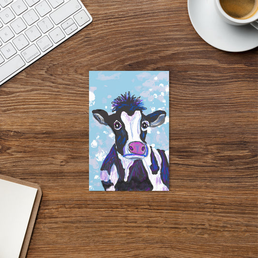 Cow Postcard, shown on a wooden desk with a keyboard and a cup of coffee, animal spirit represents the divine feminine