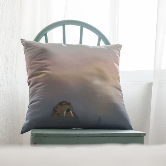 Pillow with a walrus bobbing in a misty sea sitting on a green chair against a sunlit white curtain background