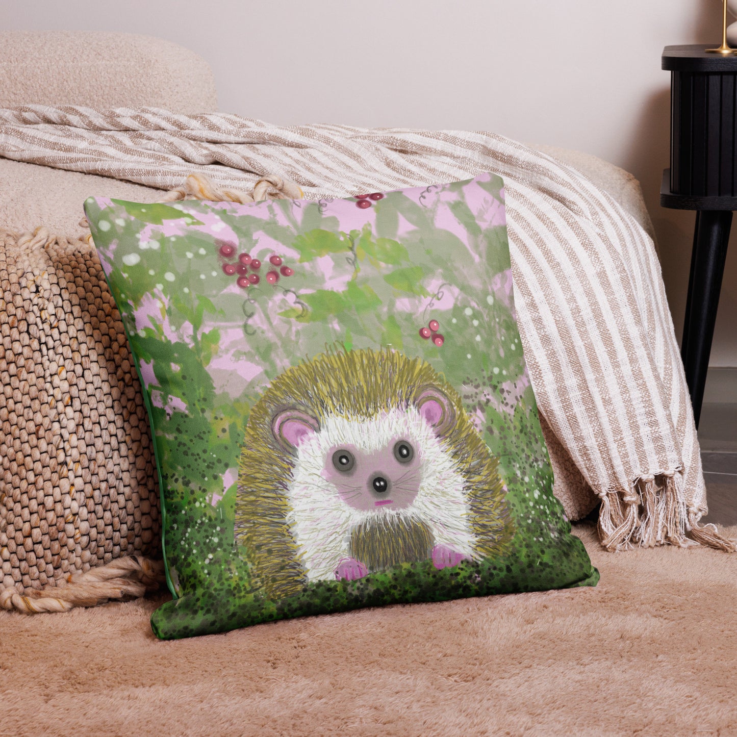 Cute decorative pillow with a garden critter, the hedgehog.  Hedgehog is shown among berries and brambles with greens and pinks. Hedgehog, with his sweet face, is gentle and kind spirit animal / spirit guide connected to Mother Earth. Shown here on as an accent pillow on the beige couch. 2 sizes. 18x18 and 22x22.