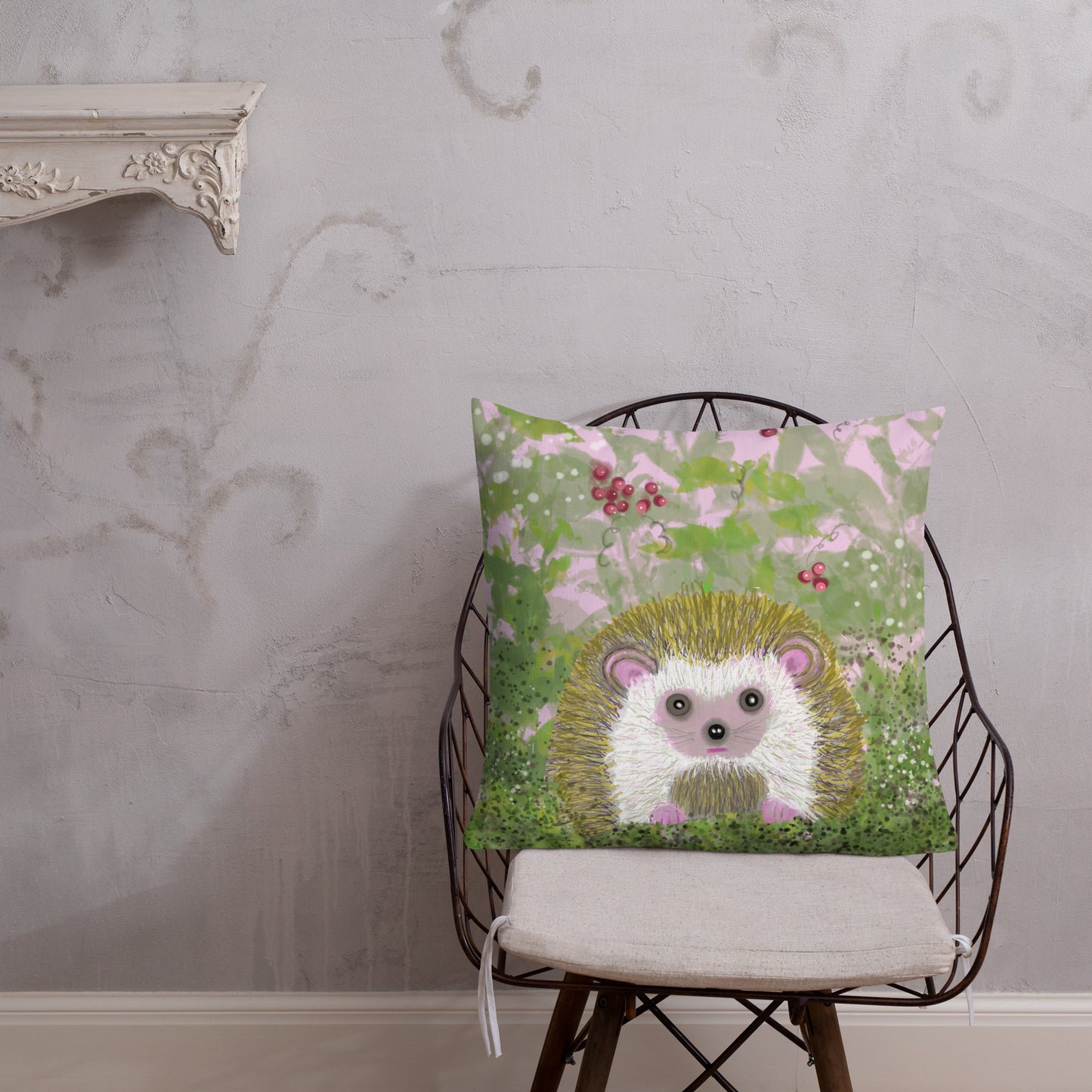 Cute decorative pillow with a garden critter, the hedgehog.  Hedgehog is shown among berries and brambles with greens and pinks. Shown here as a pillow on a chair. Hedgehog, with his sweet face, is gentle and kind spirit animal / spirit guide connected to Mother Earth. 2 sizes. 18x18 and 22x22.