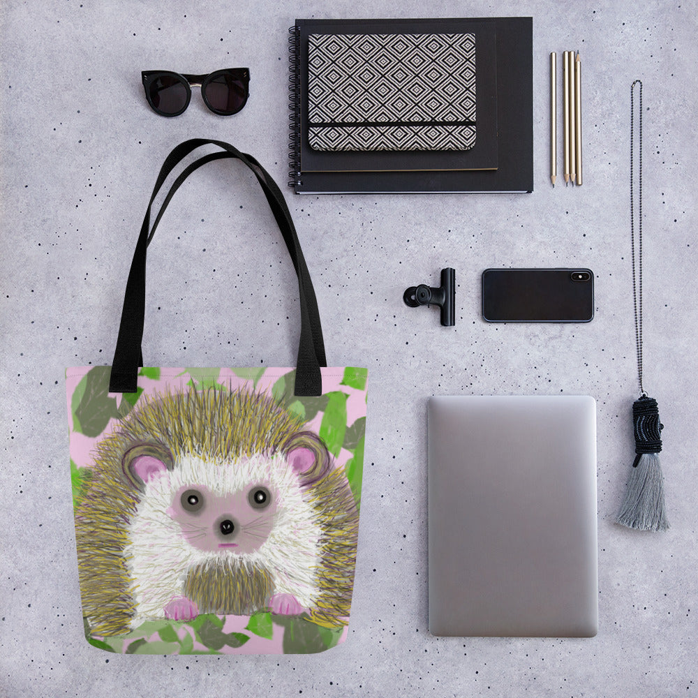 A cute tote bag with a picture of a hedgehog on a field of pink and greens. Large enough to hold laptops and notebooks and all the necessities for a trip to the office or the coffee shop.