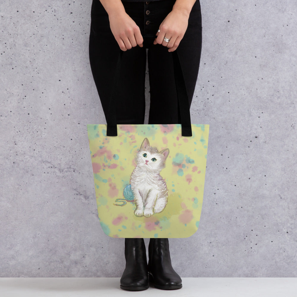 A cute little kitten tote bag to carry from office to the beach. Kitten sits on a field of yellow with pink and blue accents.