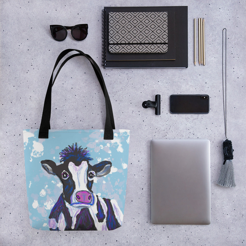 Whimsical tote bag with an image of a black and white cow against a blue sky. Large enough to hold laptops and notebooks and all the necessities for a trip to the office or the coffee shop.