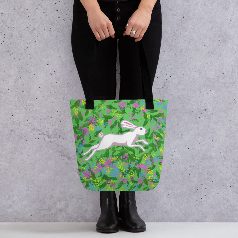 A whimsical tote bag to carry from office to the beach. Original totebag with a wild hare running through a field of flowers. White, green, pink and yellow.