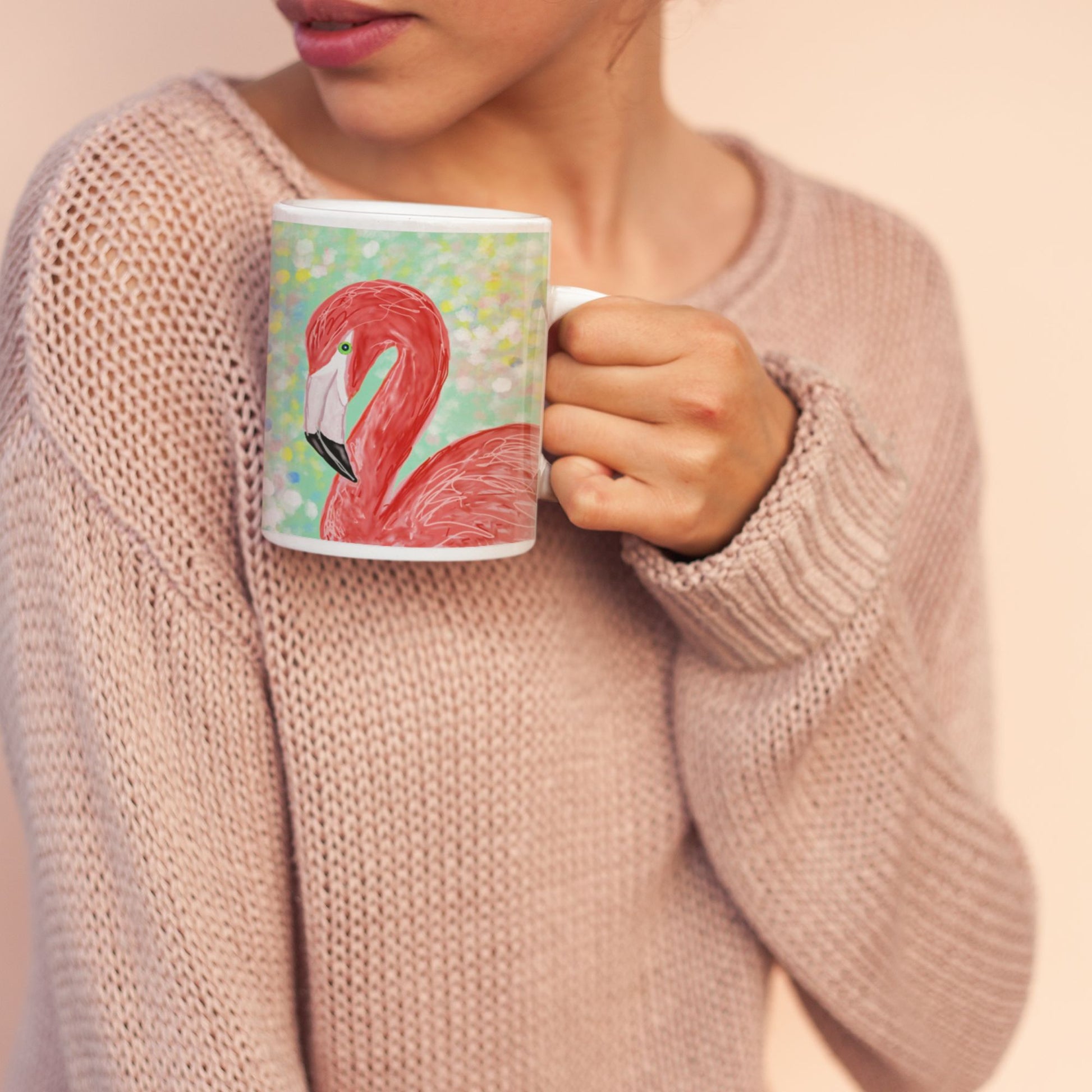 Woman holding a flamingo spirit mug against a soft pink background.