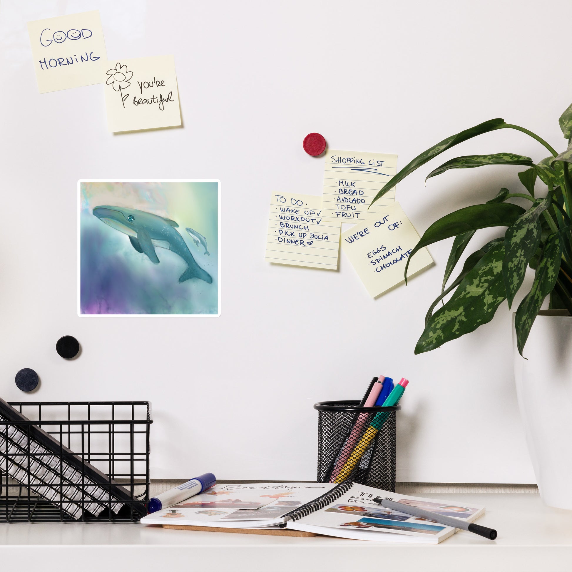 Whale magnet on whiteboard with desk, stationery items, and a plant. Whale is a symbol of wisdom.