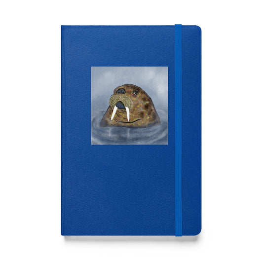 Walrus  on blue hardcover notebook/journal. Gentle giant, spirit guide, medicine man. Close up of Walrus head popping out of the sea. Product mockup shown against white  background.