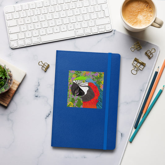 Blue notebook with a colorful parrot illustration on a marble desk with office supplies.