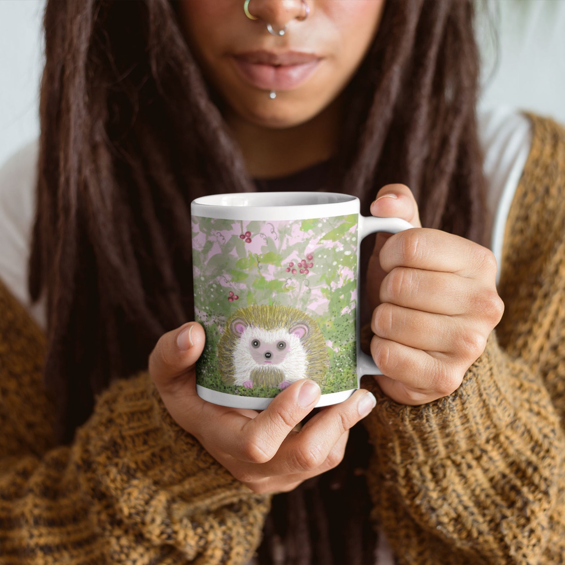 Person holding a mug with a hedgehog design against a neutral background