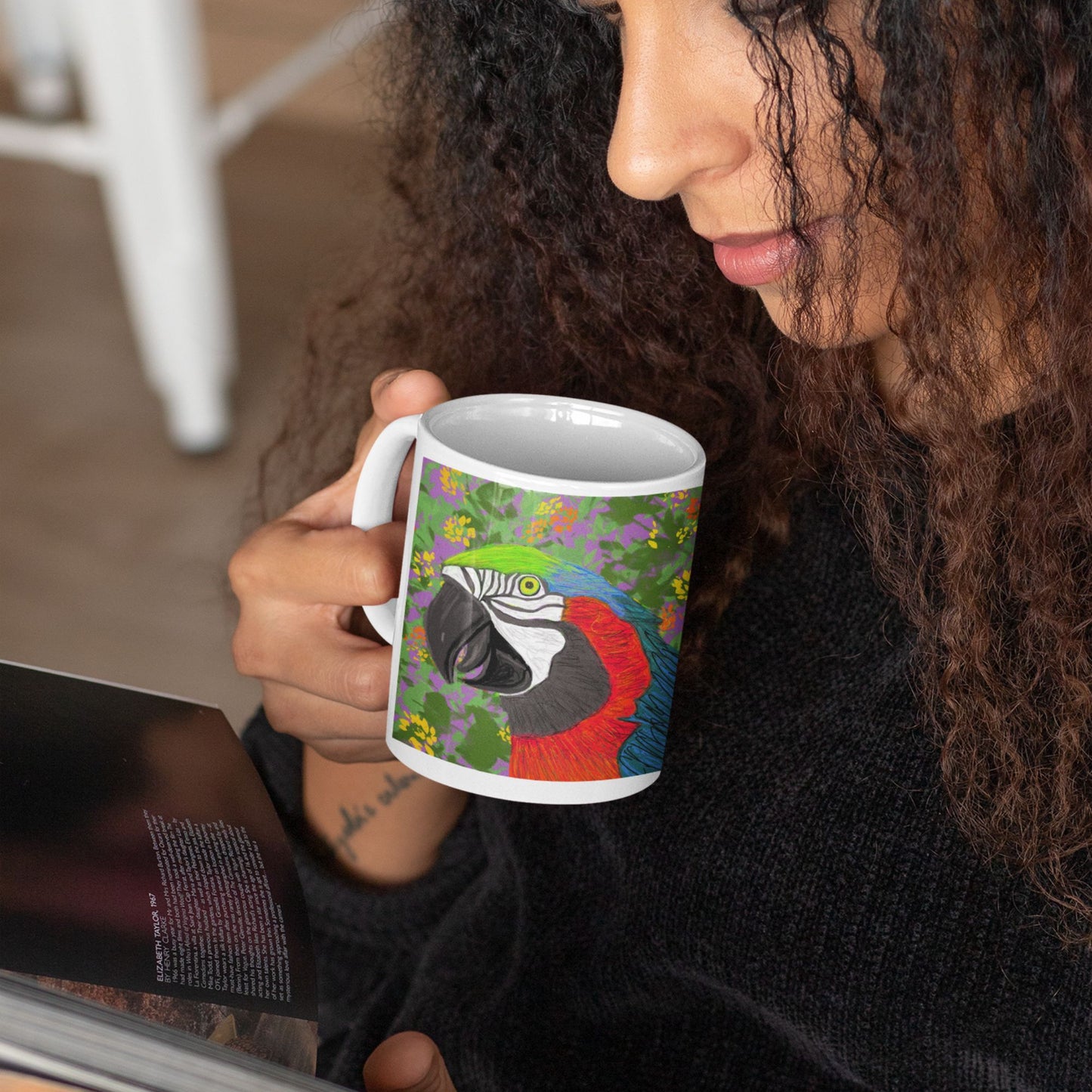 Person holding a ceramic parrot spirit mug, original design, reading indoors.