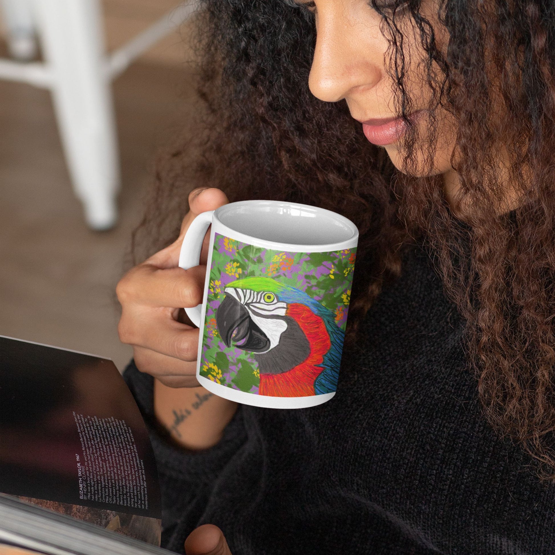Person holding a ceramic parrot spirit mug, original design, reading indoors.