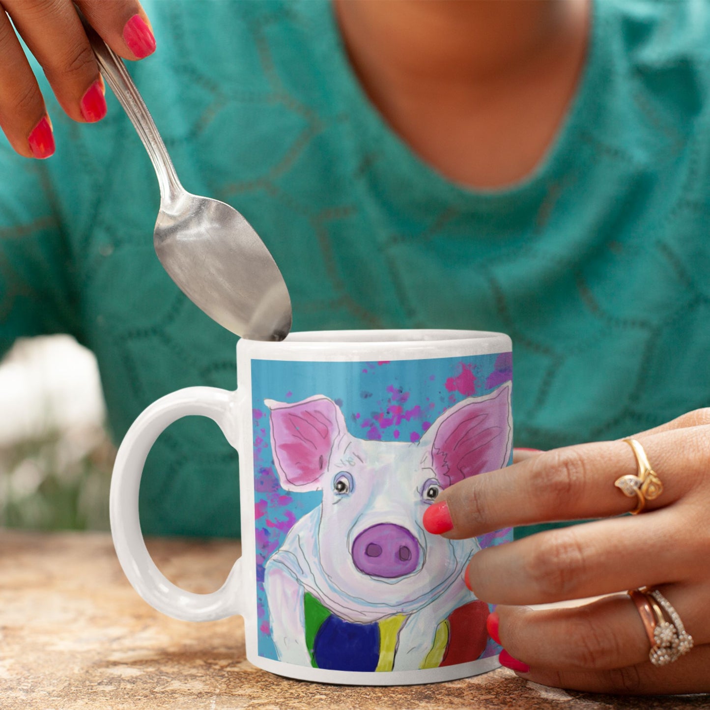 Person holding a mug with a colorful pig spirit mug.