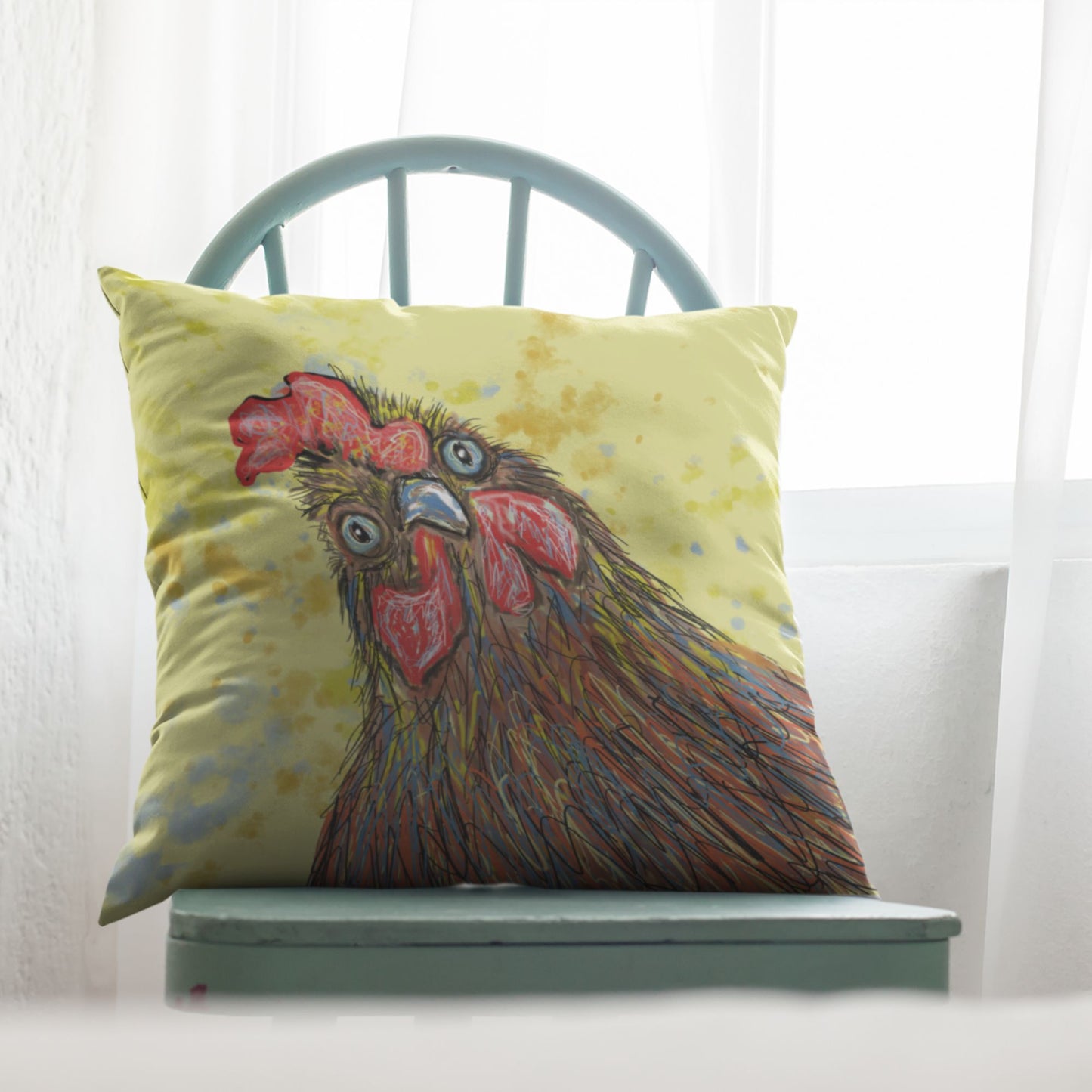 Decorative pillow with a rooster design on a green chair against a white curtain background