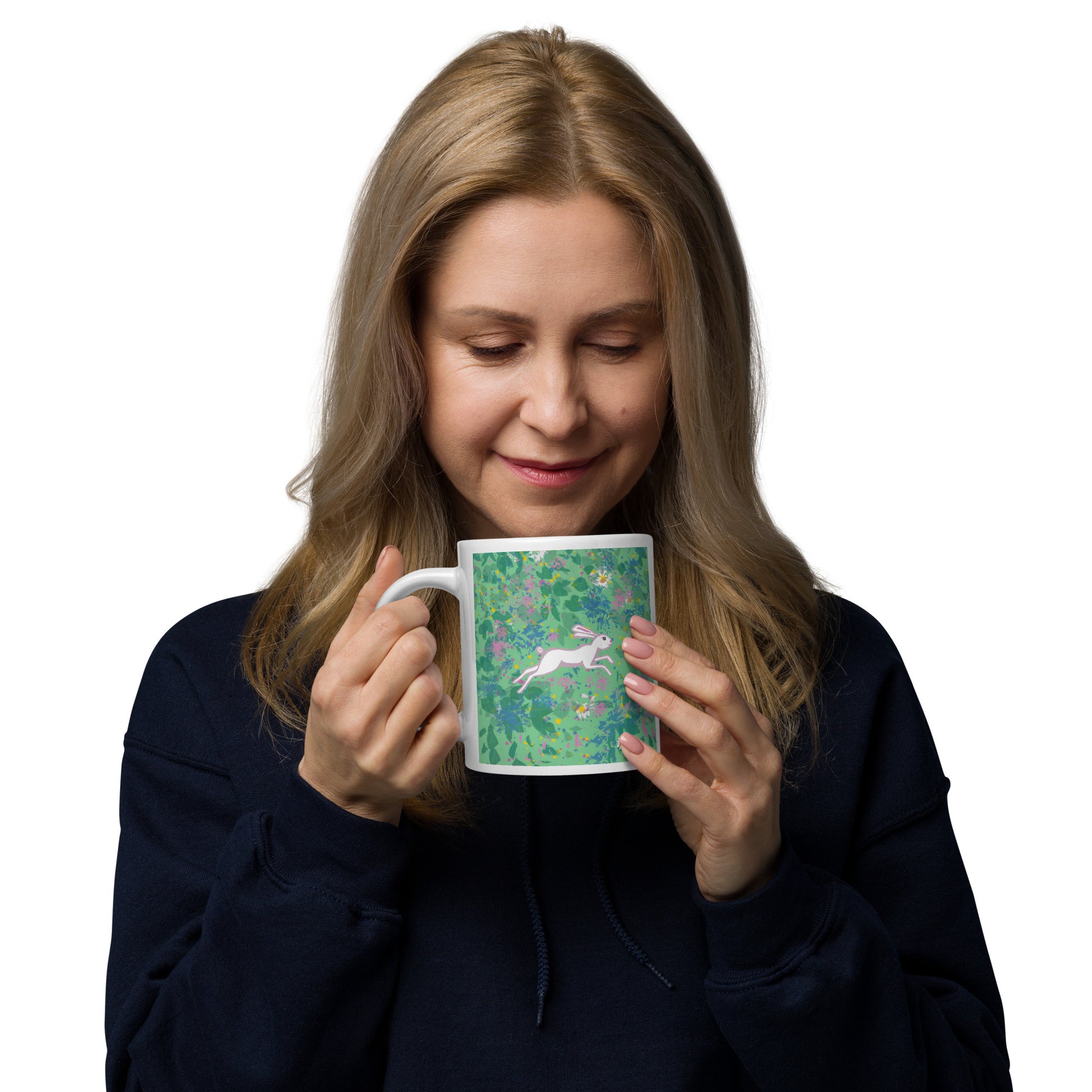 Woman holding a mug with a floral design and a white hare or rabbit on a white background