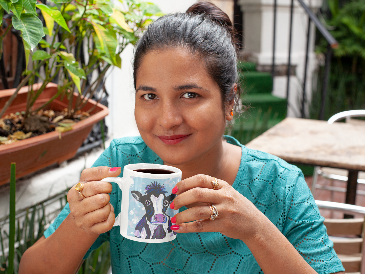 Is this original design of a cow on a mug by PittaPat your spirit animal? The cow  mug is shown here being held by a woman in a cafe enjoying her coffee break.