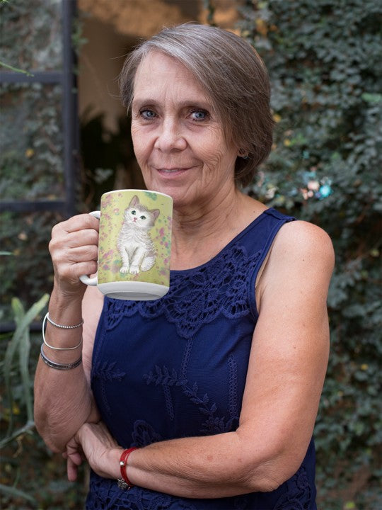 Is this original design of a kitten on a mug by PittaPat your spirit animal? The kitten mug is shown here being held by a woman in a garden enjoying her coffee break.