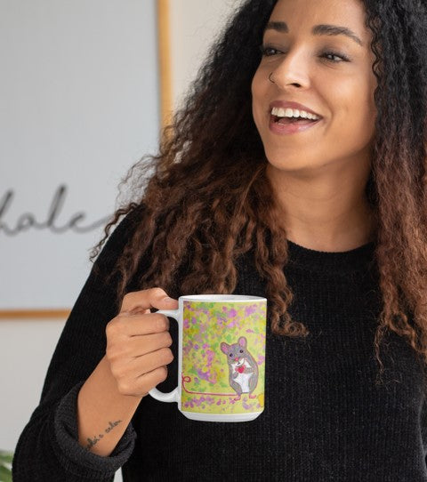 Is this mouse on a mug by PittaPat your spirit animal? The mouse mug is shown here being held by a smiling woman enjoying her coffee break.