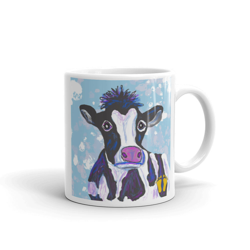 Coffee mug for cow lovers. Unique cow design has a  soulful expression. Cow on field of blue and white. Stamped with artist's golden toes mark. 11 oz mug