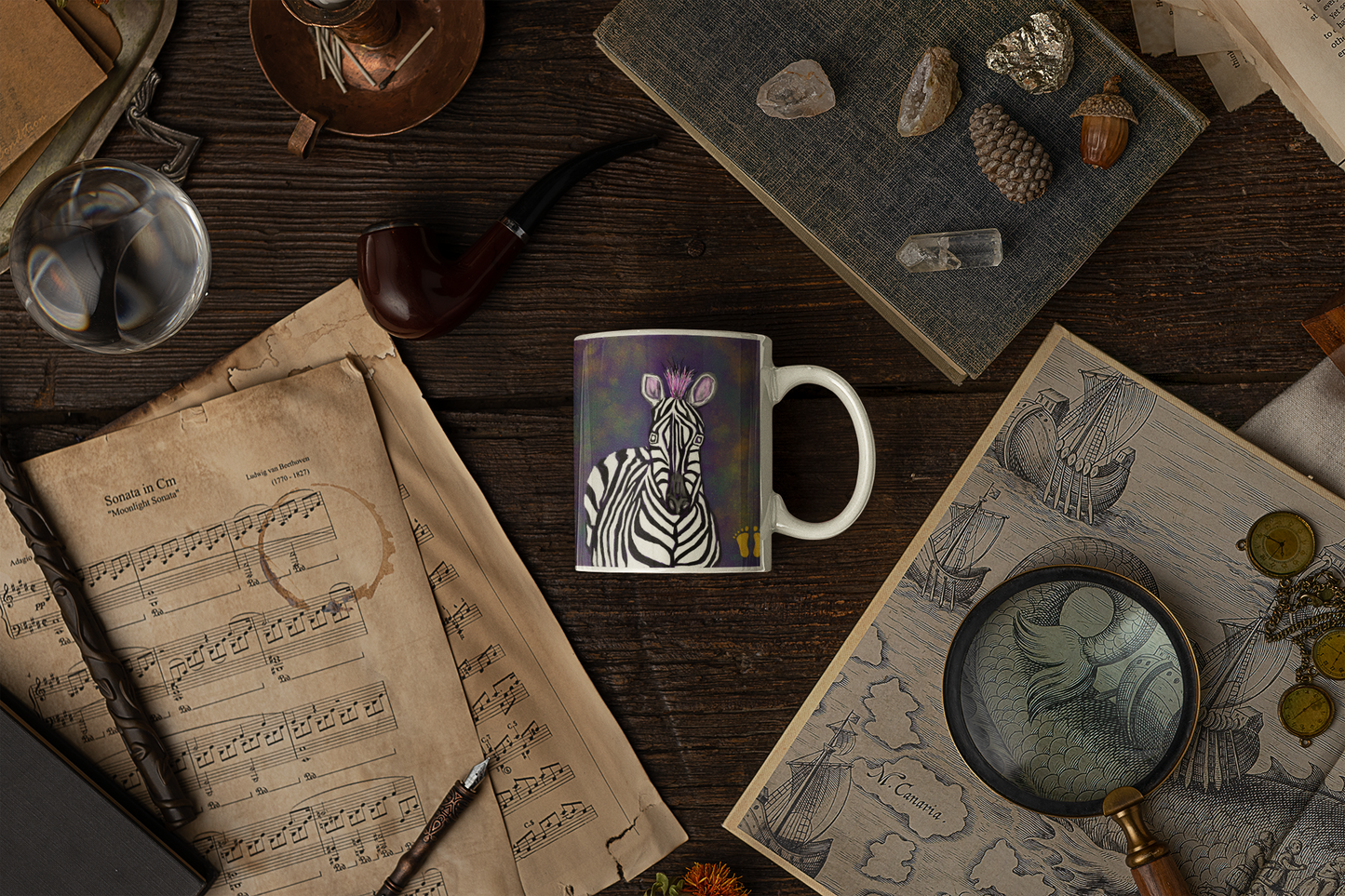 Premium ceramic coffee mug is a unique gift for animal lovers. Brightly colored zebra is on a field of black and gold. Shown here on a desk with a map and books.